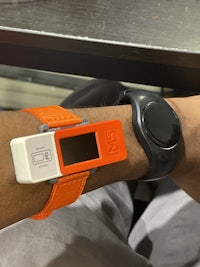 a person's wrist with an orange watch attached to it