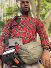 a man wearing a plaid shirt and carrying a backpack