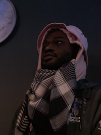 a man wearing a pink hoodie and scarf