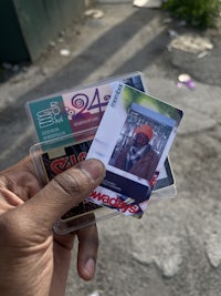 a person holding a pair of plastic cards