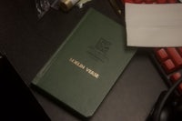 a green book on a desk next to a keyboard