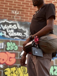 a man standing in front of a wall with graffiti on it