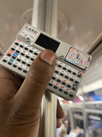 a person holding a small electronic device on a train